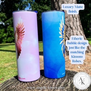 May include: Two insulated tumblers with a matte finish. One is light purple with a wing design in shades of pink and red. The other is blue with a gold and blue wing design. The text on the tumblers says "Luxury Matte finish" and "Etheric Bubble design".