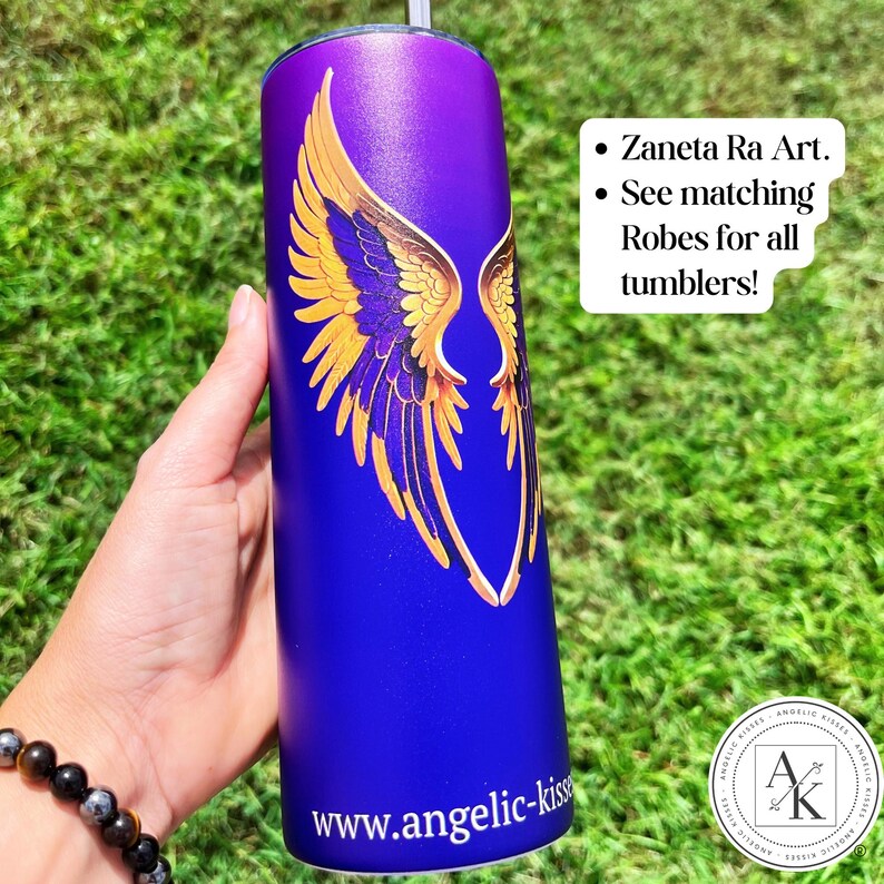 May include: A purple and blue tumbler with a gold angel wing design. The tumbler has the text "www.angelic-kiss" at the bottom. The text "Zaneta Ra Art" and "See matching Robes for all tumblers!" is also visible.