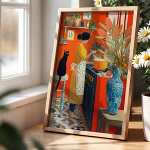 K&ouml;nnte beinhalten: Gerahmter Kunstdruck, der eine Frau in einem gelben Kleid und einer Sch&uuml;rze beim Kochen in einer K&uuml;che zeigt. Eine schwarze Katze sitzt auf einem Hocker. Das Kunstwerk hat einen leuchtend orangefarbenen Hintergrund, eine blaue Vase und einen Blumenstrau&szlig;.