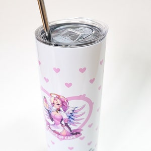 Puede incluir: Un vaso de acero inoxidable blanco con un patr&oacute;n de corazones rosas y una ilustraci&oacute;n rosa y blanca de un personaje femenino con alas y un halo. El vaso tiene una tapa transparente y una pajita de acero inoxidable. El texto "A Piece of Cake" y "xoxo Angela" est&aacute;n impresos en el vaso.