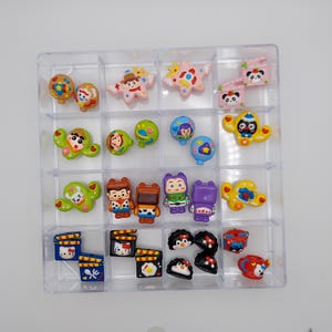 Puede incluir: Un organizador de plástico transparente lleno de figuras en miniatura coloridas. Las figuras incluyen personajes de dibujos animados, animales y otros objetos decorativos. El organizador está dividido en múltiples compartimentos, cada uno con una figura diferente. Las figuras son de plástico y tienen colores brillantes.