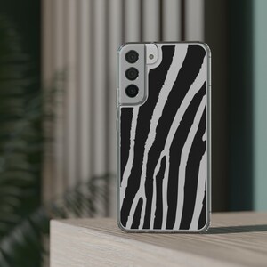 May include: A clear phone case with a black and white zebra print design. The case has a raised camera bump with three camera lenses.