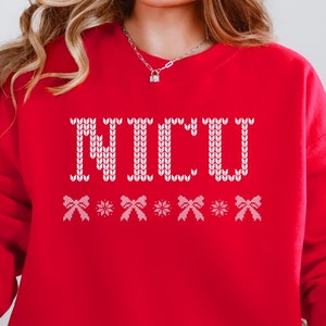 May include: Red sweatshirt with a white knitted design that says "NICU" with white bows underneath.