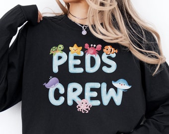 May include: Black sweatshirt with a graphic of sea creatures and the text "PEDS CREW".