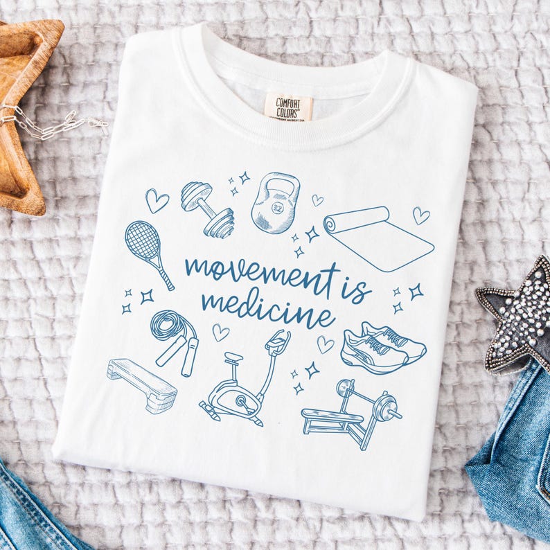 May include: White t-shirt with a blue graphic design of various fitness equipment and the text "movement is medicine".