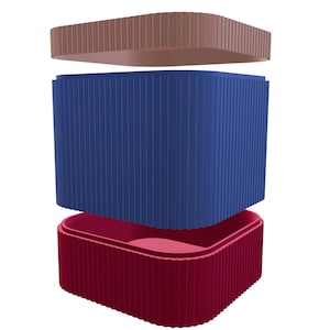 Peut inclure: Un ensemble de trois boîtes de rangement carrées avec des côtés nervurés. La boîte supérieure est brune, la boîte du milieu est bleue et la boîte du bas est rouge.