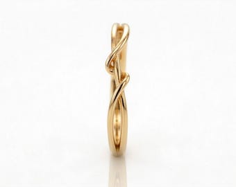May include: A gold-colored ring with a unique, intertwined design. The ring features a continuous, flowing pattern that wraps around the band. The ring's design is elegant and modern, suitable for everyday wear or special occasions.