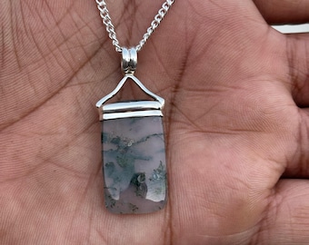 May include: A silver chain necklace with a pendant featuring a rectangular green and pink agate stone.