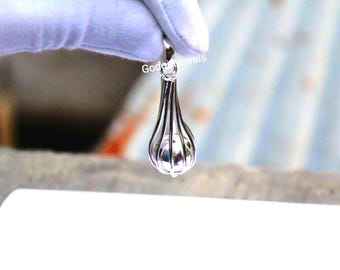 May include: A silver pendant shaped like a teardrop with a cage design. The cage is made of thin metal bars and encloses a small, round ball.