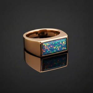 Puede incluir: Un anillo de oro rosa con una piedra de ópalo rectangular iridiscente. El ópalo muestra una mezcla de colores azules, verdes y rojos. El anillo tiene un diseño simple y moderno sobre un fondo oscuro.