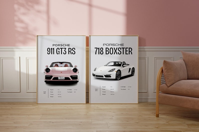 May include: Two framed posters featuring illustrations of Porsche cars. The left poster shows a pink Porsche 911 GT3 RS, while the right poster shows a white Porsche 718 Boxster.
