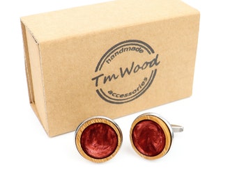 May include: A pair of round wooden cufflinks with a red resin inlay. The cufflinks are in a brown cardboard box with a logo that says "handmade Tm Wood accessories".