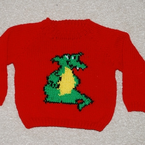 Peut inclure: Pull-over rouge en tricot avec un motif de dragon vert et jaune.