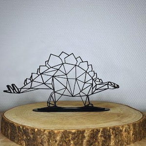Könnte beinhalten: Schwarze geometrische Dinosaurierskulptur aus Metall auf einem Holzsockel. Der Dinosaurier steht mit dem Kopf zur Seite gedreht.