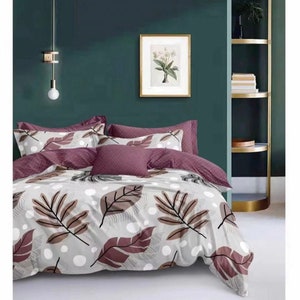 May include: A grey and white bedding set with a leaf pattern in shades of brown and purple. The bedding set includes a duvet cover, two pillowcases, and a decorative pillow.