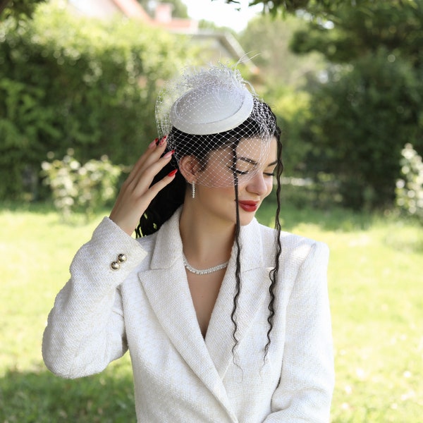 Bandeau blanc fait à la main avec des plumes et des perles pour la mariée. Chapeau de mariage avec voile de visage en tulle. Coiffe de mariage élégante. Chapeau de mariage de style.