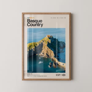 May include: A framed print featuring a scenic view of the Basque Country coastline. The image showcases a rocky island with a building on top, connected to the mainland by a bridge. The print has the words "Basque Country" at the top.