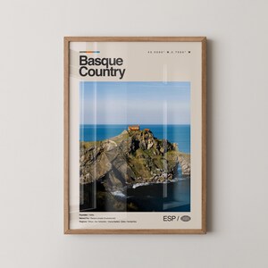 Peut inclure: Impression encadrée représentant un paysage côtier avec un petit bâtiment sur une île rocheuse, sur fond de mer et de ciel bleus. L'impression comprend le texte "Basque Country", des coordonnées géographiques et l'abréviation "ESP".