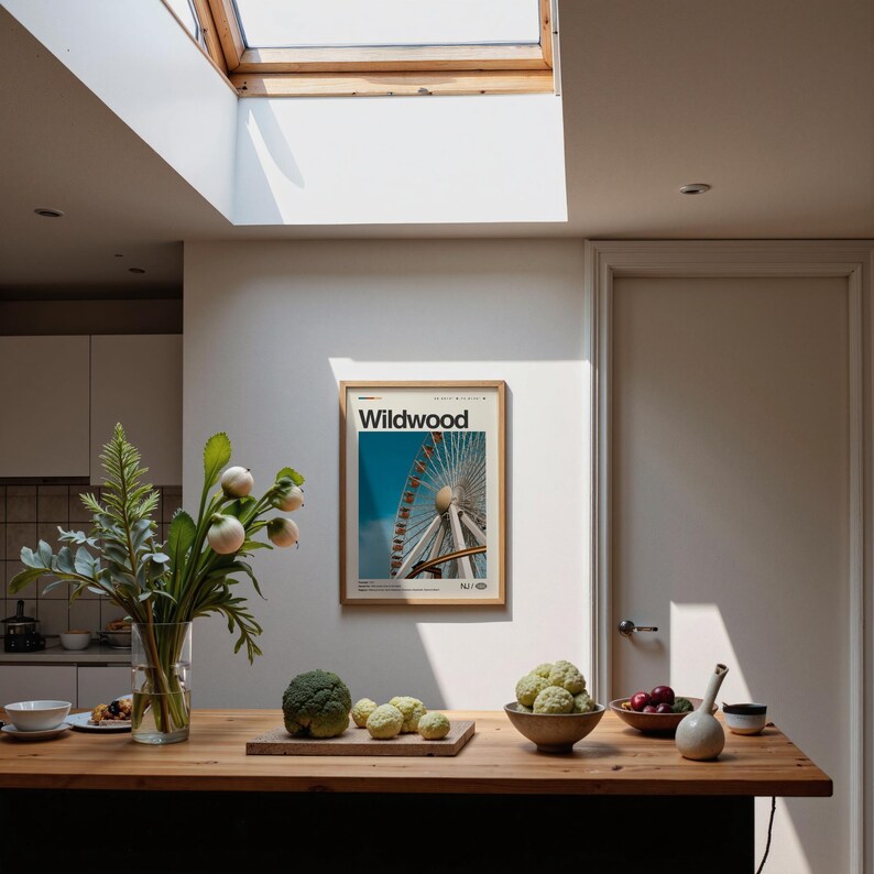 May include: A kitchen scene with a wooden countertop and a framed poster that reads "Wildwood." The poster features a Ferris wheel against a blue sky. A vase of flowers and various fruits and vegetables are on the counter.