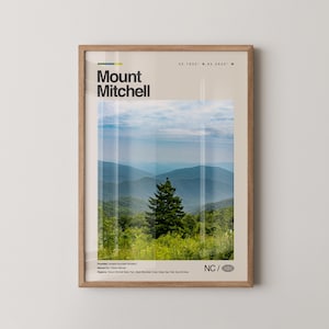 Könnte beinhalten: Ein gerahmter Druck mit einer malerischen Ansicht des Mount Mitchell. Der Druck zeigt den Namen des Berges in fetter Schrift, Koordinaten und ein Landschaftsfoto des Gebirges. Das Bild ist in einem hellbraunen Holzrahmen eingefasst.