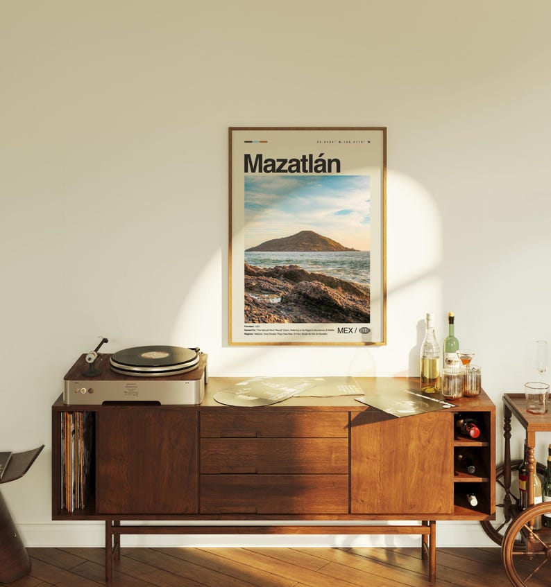 May include: A vintage-style wooden cabinet with a record player on top. The cabinet has three drawers and a shelf for storing records. A poster with the text "Mazatl&aacute;n" and a picture of a beach scene is hanging on the wall behind the cabinet.