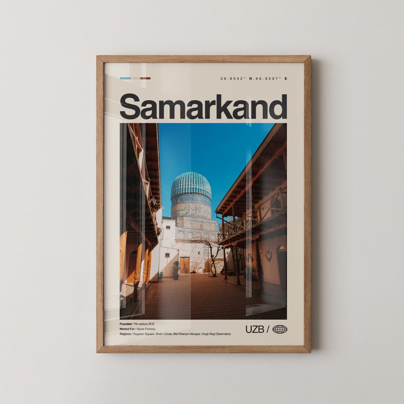 May include: Framed print featuring a photograph of Samarkand, Uzbekistan, with the city name in large black letters. The image shows a blue-domed building and surrounding architecture under a clear blue sky. The frame is light brown.