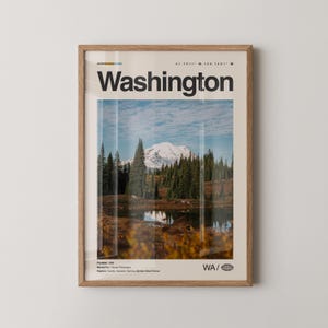 May include: A framed print featuring a scenic view of Washington state. The image showcases a snow-capped mountain, evergreen trees, and a reflective lake. The word "Washington" is displayed in bold, black text at the top.