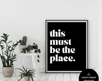 Op de afbeelding: Zwart-witte printbare wandkunst met de tekst "this must be the place."