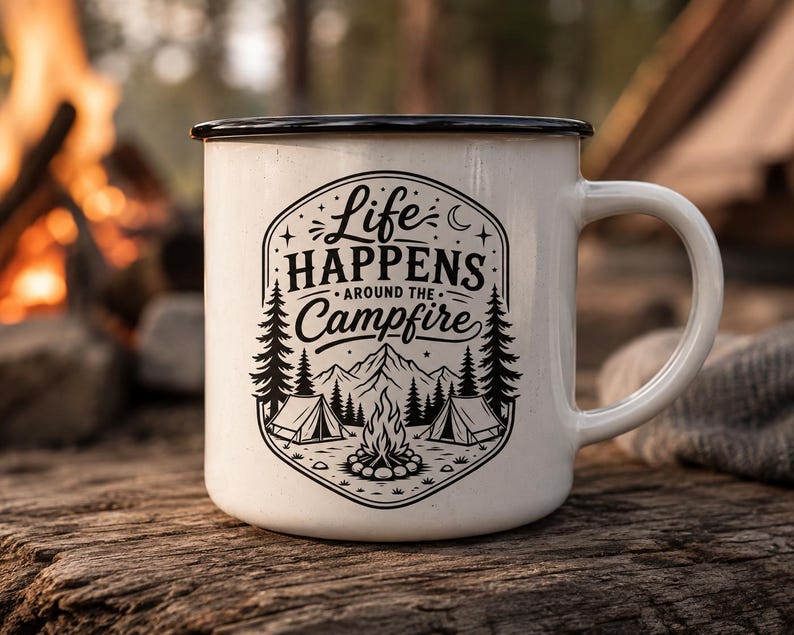 May include: A white enamel mug with a black rim and a black graphic print featuring the text Life Happens Around the Campfire, accompanied by illustrations of a campfire, two tents, pine trees, mountains, a crescent moon, and small stars.
