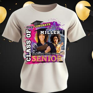 May include: White t-shirt with a pink, purple, and gold design. The design includes the text "Class of 2025 Congrats Ashley Miller Hamilton High School Senior". A photo of two people in graduation gowns is in the center of the design.