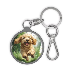 May include: A silver key chain with a round charm featuring a watercolor illustration of a happy golden doodle dog running through a green field.