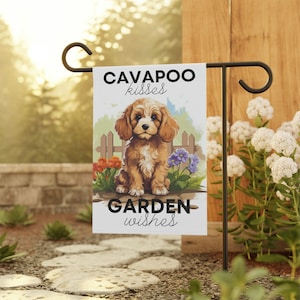 Può includere: Una bandiera da giardino bianca con un cucciolo di Cavapoo marrone e bianco seduto davanti a un recinto bianco. La bandiera ha il testo "Cavapoo kisses" in alto e "Garden wishes" in basso.