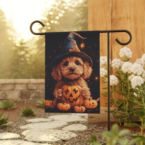 May include: A brown and white dog wearing a witch's hat holds a jack-o'-lantern in its paws. The dog is surrounded by smaller pumpkins. The image is set against a dark background with stars.