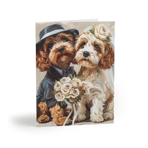 May include: A wedding greeting card featuring two Cavalier King Charles Spaniels. One dog is dressed in a tuxedo and hat, the other in a veil and floral headpiece. They hold a bouquet of white roses.