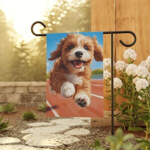May include: A garden flag featuring a brown and white puppy running on a red track. The puppy has a happy expression and is looking directly at the viewer.