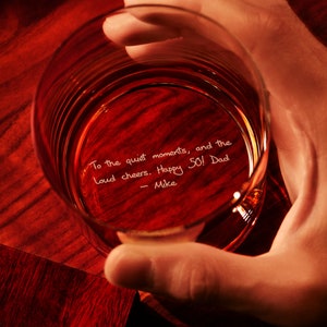 May include: A clear glass with a handwritten message inside: "To the quiet moments, and the loud cheers. Happy 50! Dad - Mike"