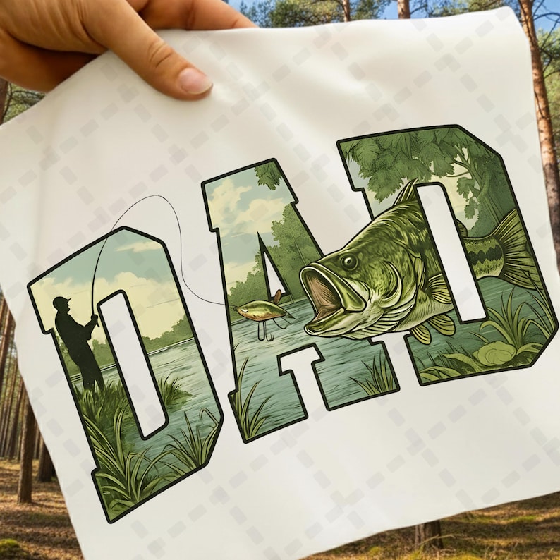 May include: White fabric with the word "DAD" in green, with a fishing scene inside the letters. The letter "D" shows a fisherman casting a line, and the letter "D" shows a large mouth bass. The letter "A" shows a lure.
