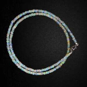 May include: A delicate necklace made of iridescent opal beads. The necklace is double-stranded and features a silver clasp.