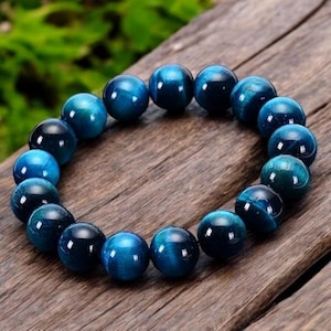 May include: A blue tiger's eye beaded bracelet with round beads.
