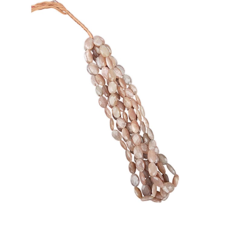 May include: A strand of oval-shaped sunstone beads in shades of peach and white. The beads are strung on a brown cord.