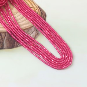 May include: A strand of pink gemstone beads. The beads are faceted and have a shiny finish. The strand is approximately 18 inches long.