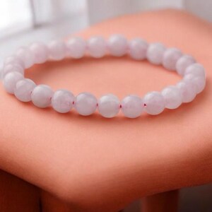 May include: A light purple gemstone bracelet with small round beads.