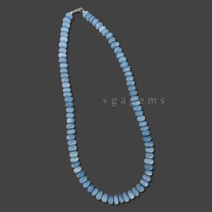 Op de afbeelding: Een lichtblauwe edelsteenketting gemaakt van ronde kralen. De ketting is ongeveer 45 centimeter lang en heeft een zilveren sluiting.
