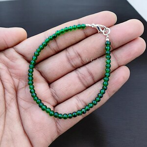 以下が含まれることがあります： 銀色の留め具が付いた緑色の宝石ビーズのブレスレットです。
