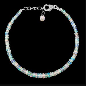 May include: A silver chain bracelet with a silver clasp and a row of iridescent opal beads.