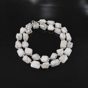 Puede incluir: Collar de piedra howlite blanca con cuentas de plata. El collar está hecho de cuentas de forma irregular y mide aproximadamente 45 cm de largo.