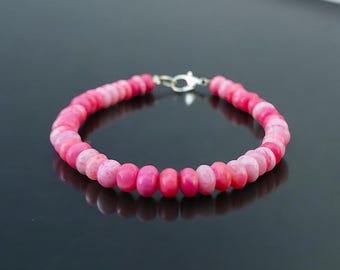 May include: A pink and white beaded bracelet with a silver clasp.