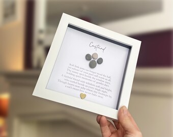 May include: A white square shadow box frame containing a memorial tribute for a cat named Custard. The display features a paw print design made of five small gray pebbles, a printed poem about a pet, and a small gold heart at the bottom center.