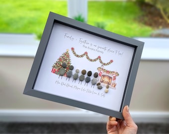 May include: A framed wall art piece featuring a pebble art family portrait with seven figures and a dog. The print includes a Christmas tree, fireplace, and the text: Family - Together is our favorite place to be! The Evans Family. Names are listed below.