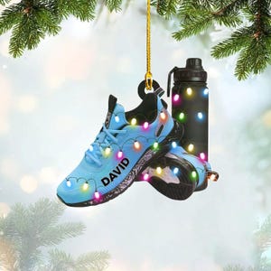 A pair of blue sneakers decorated with colorful Christmas lights, hanging from a string.